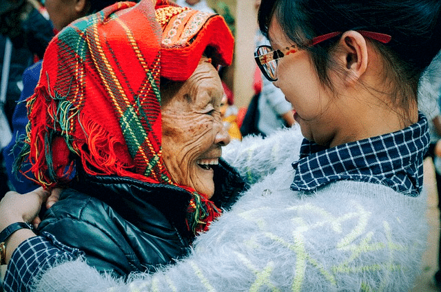 Aider les personnes âgées (une jeune femme serre dans ses bras une femme âgée).